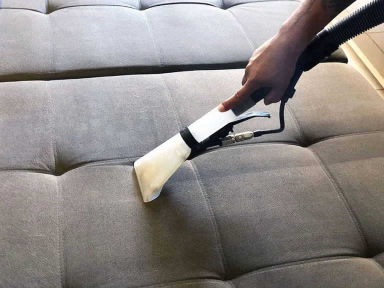 Limpeza de estofados com equipamento profissional em textura cinza claro.