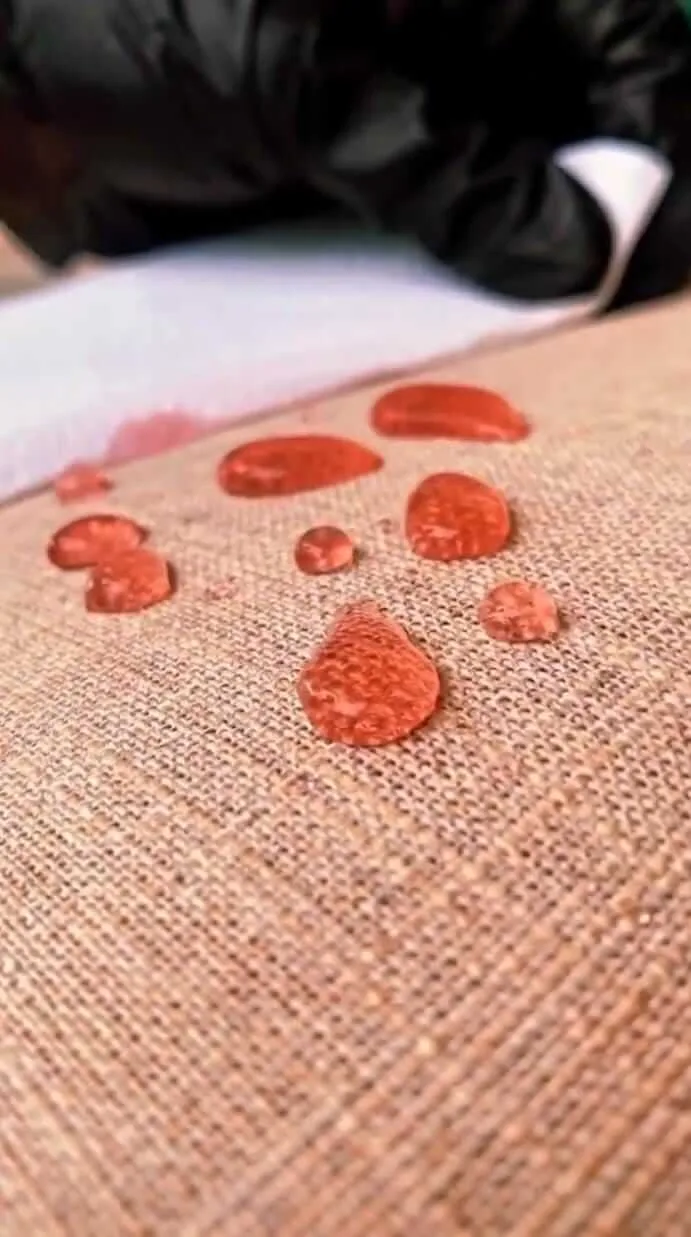 Gotas de água sobre tecido impermeabilizado, demonstrando proteção contra manchas.