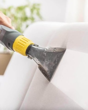 Aspirador sendo usado em estofado para limpeza profunda